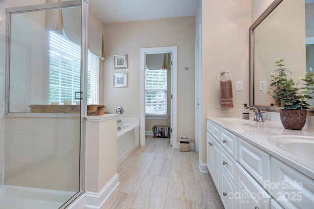 5748 Timbertop Ln, Charlotte, NC 28215 - bathroom with double vanity, a stall shower, a garden tub, and baseboards