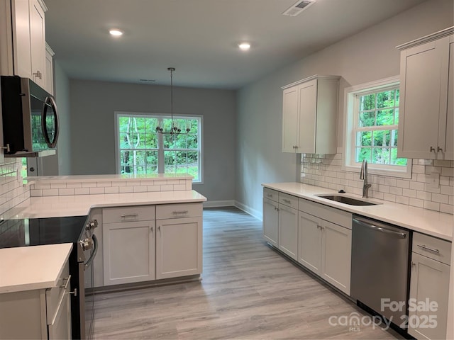 kitchen with stainless steel appliances, a sink, tasteful backsplash, baseboards, and recessed lighting