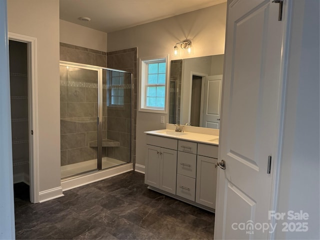full bath with a shower stall, vanity, and a spacious closet