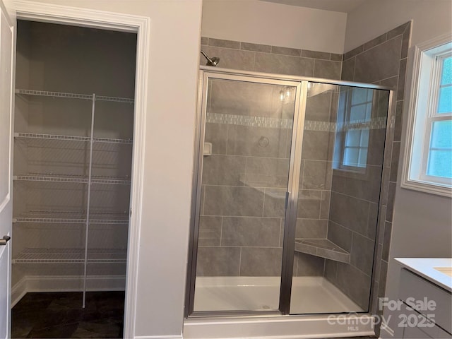 full bath with a shower stall, vanity, and a spacious closet