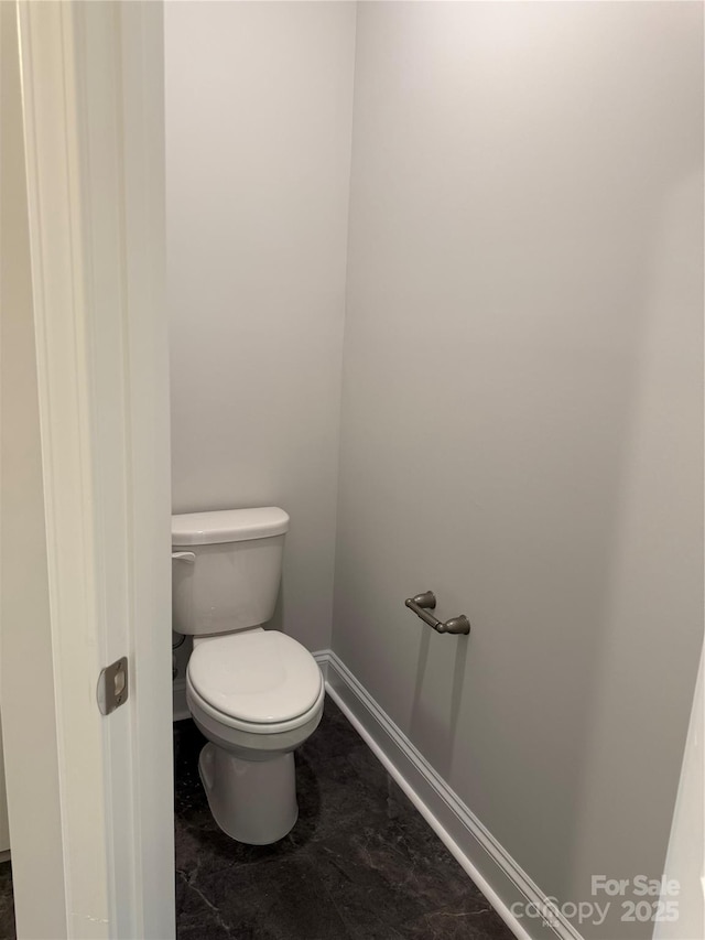 bathroom with baseboards and toilet