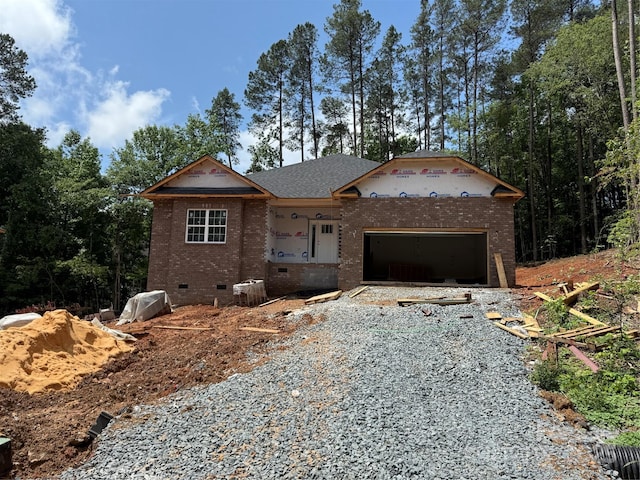 unfinished property with crawl space, brick siding, driveway, and a garage