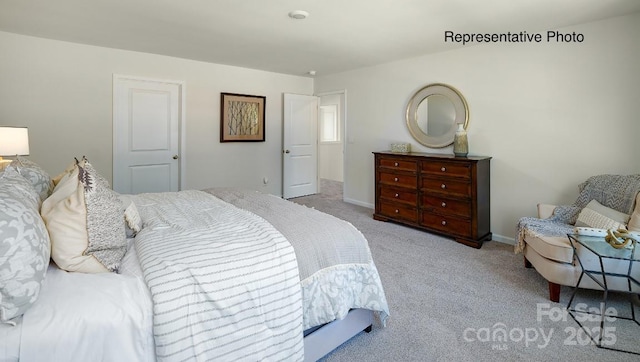 bedroom featuring light colored carpet and baseboards