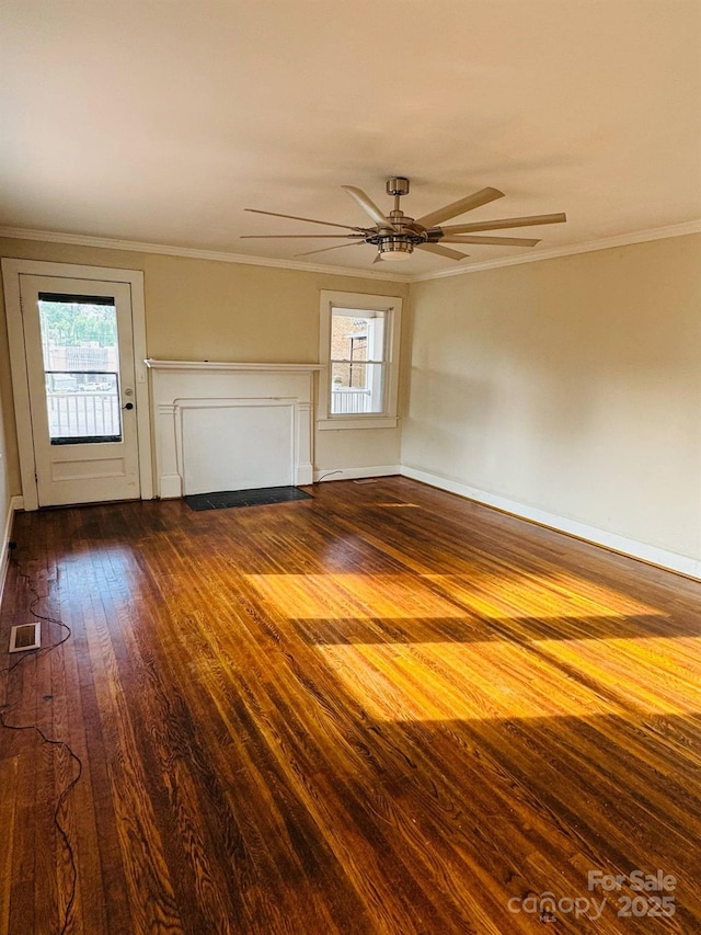 unfurnished living room with ceiling fan, dark wood finished floors, ornamental molding, and baseboards