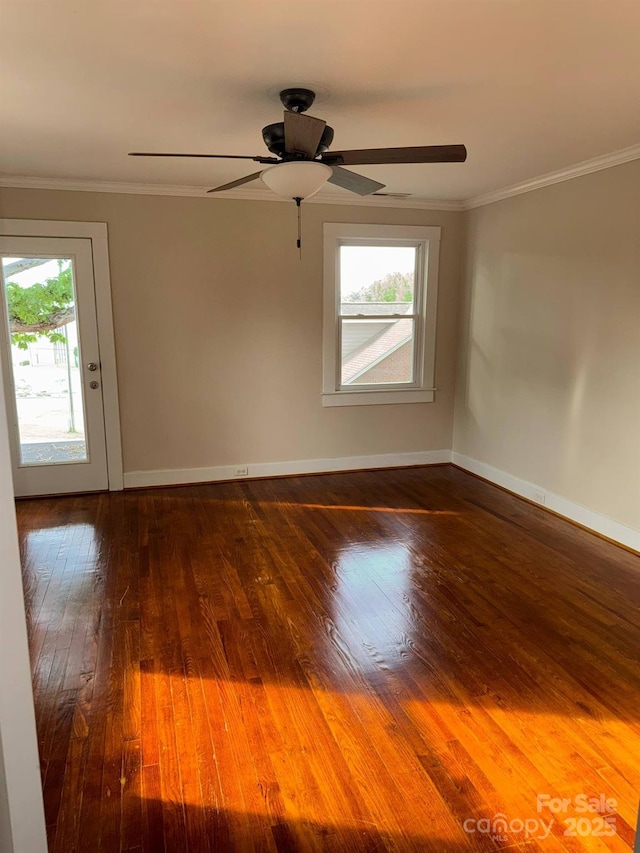 spare room featuring hardwood / wood-style flooring, ornamental molding, baseboards, and a ceiling fan