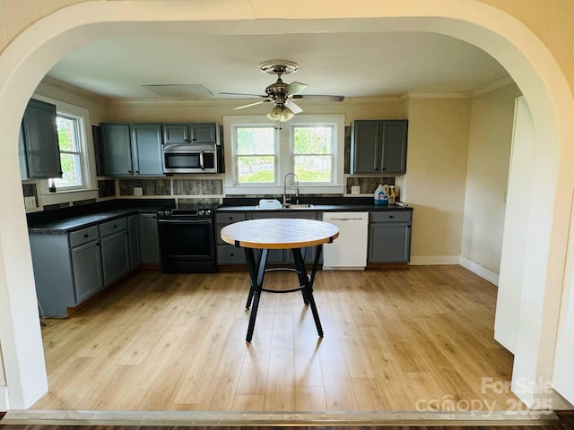 kitchen featuring black / electric stove, white dishwasher, stainless steel microwave, arched walkways, and crown molding