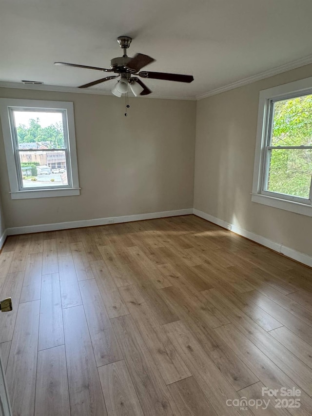 spare room with light wood-style flooring, crown molding, baseboards, and ceiling fan