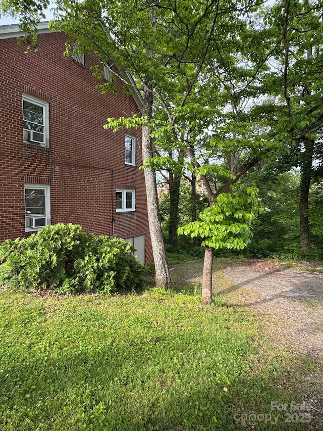view of property exterior featuring brick siding and a yard