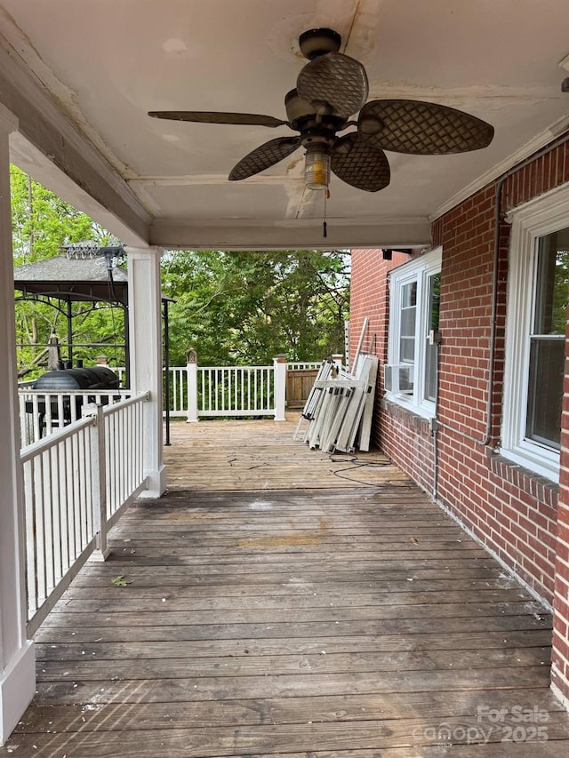wooden terrace featuring ceiling fan, grilling area, and cooling unit