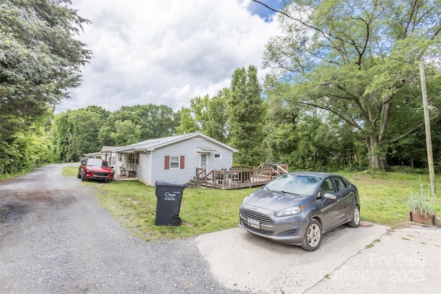 100 Lanier St, Mount Holly, NC 28120 - view of front of house featuring a deck, a front lawn, and driveway