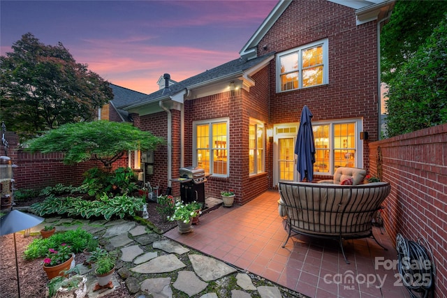 3128 Ethereal Ln, Charlotte, NC 28226 - back of house at dusk with brick siding, a patio area, and an outdoor living space