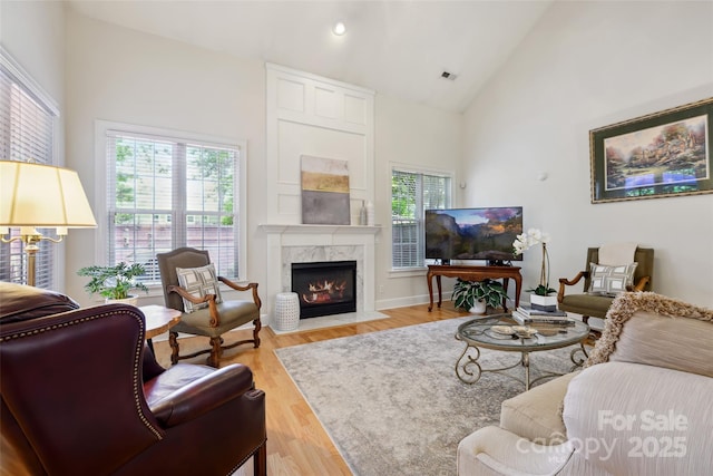 3128 Ethereal Ln, Charlotte, NC 28226 - living room featuring a premium fireplace, high vaulted ceiling, wood finished floors, and recessed lighting