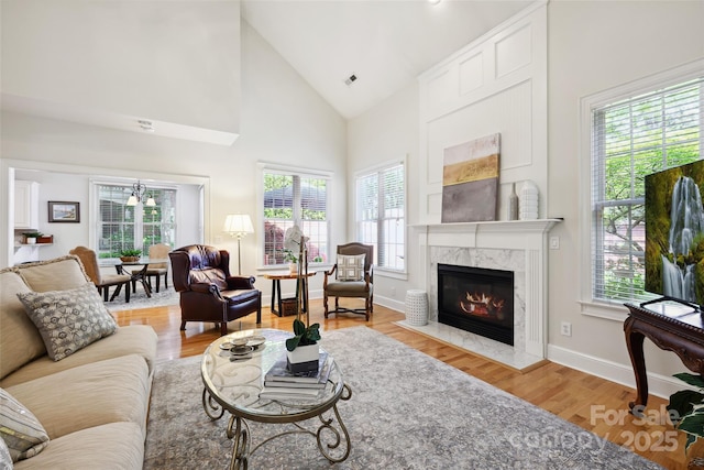 3128 Ethereal Ln, Charlotte, NC 28226 - living area featuring healthy amount of natural light, a fireplace, light wood-style flooring, high vaulted ceiling, and baseboards