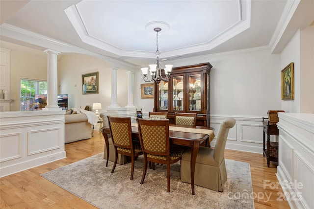 3128 Ethereal Ln, Charlotte, NC 28226 - dining area featuring decorative columns, a tray ceiling, a chandelier, light wood-style flooring, and crown molding