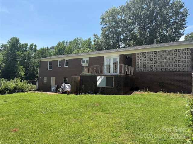 back of property with brick siding, french doors, and a yard
