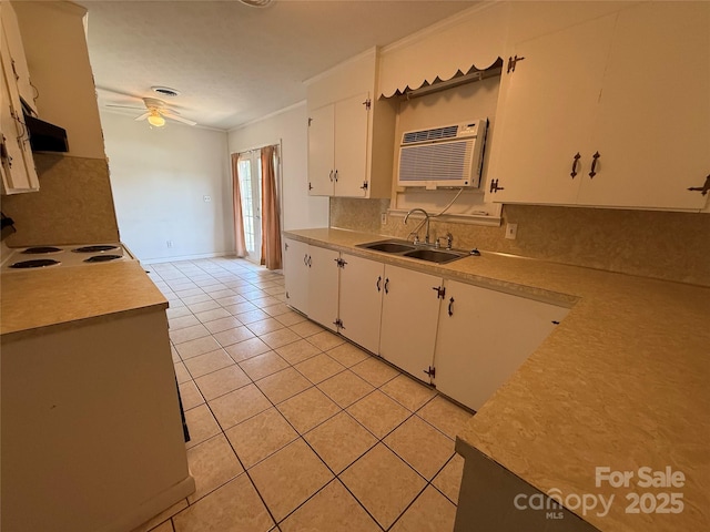 kitchen featuring a sink, a wall unit AC, a ceiling fan, light countertops, and crown molding