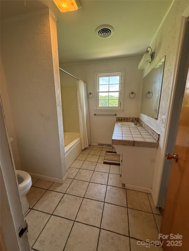 bathroom featuring toilet, tile patterned flooring, vanity, shower / bath combination with curtain, and baseboards