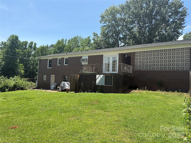 back of house with brick siding, a yard, and french doors