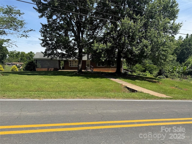 view of front of home featuring a front lawn and brick siding
