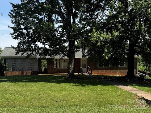 view of front facade featuring brick siding and a front yard