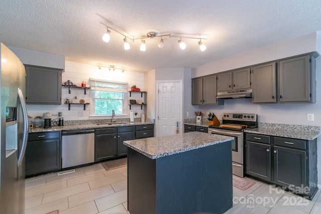 1739 Lesa Lin Dr, Monroe, NC 28112 - kitchen with stainless steel appliances, under cabinet range hood, a sink, open shelves, and a textured ceiling