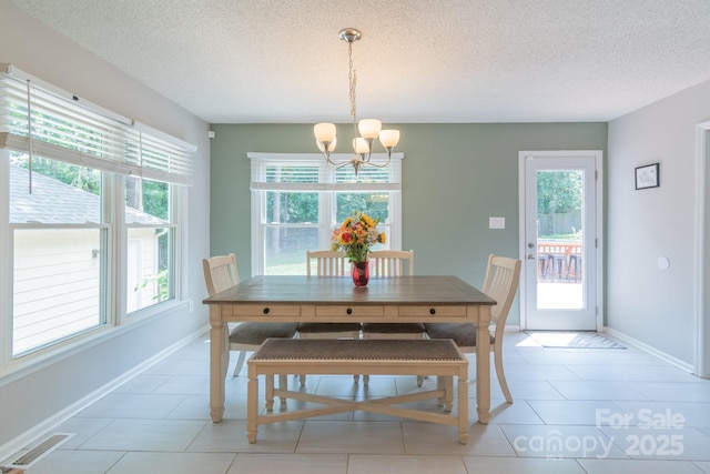 1739 Lesa Lin Dr, Monroe, NC 28112 - dining room featuring a chandelier, healthy amount of natural light, a textured ceiling, and baseboards