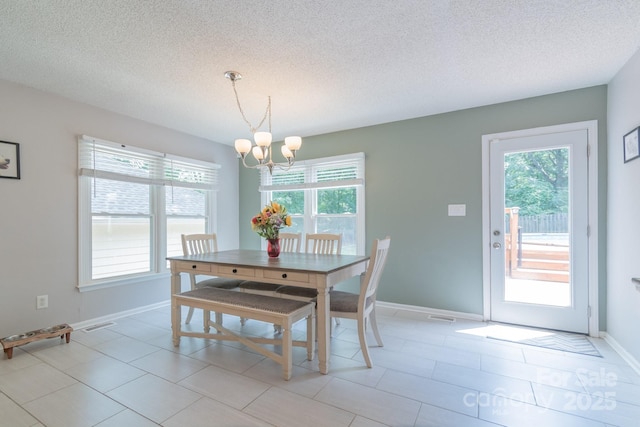 1739 Lesa Lin Dr, Monroe, NC 28112 - dining room featuring a chandelier, healthy amount of natural light, a textured ceiling, and baseboards