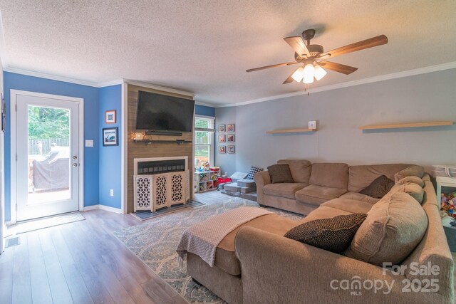 1739 Lesa Lin Dr, Monroe, NC 28112 - living room with healthy amount of natural light, a textured ceiling, wood finished floors, a fireplace, and ceiling fan