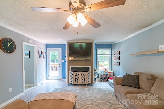 1739 Lesa Lin Dr, Monroe, NC 28112 - living room with a textured ceiling, a large fireplace, wood finished floors, ornamental molding, and plenty of natural light