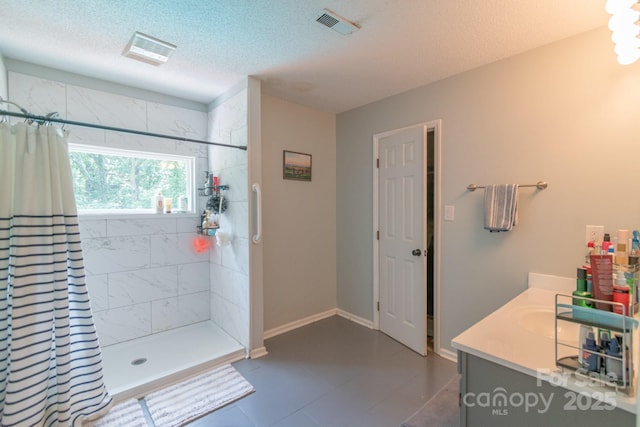 1739 Lesa Lin Dr, Monroe, NC 28112 - bathroom with tiled shower, a textured ceiling, vanity, tile patterned floors, and baseboards
