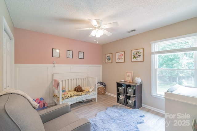 1739 Lesa Lin Dr, Monroe, NC 28112 - bedroom featuring wood finished floors, multiple windows, a textured ceiling, and ceiling fan