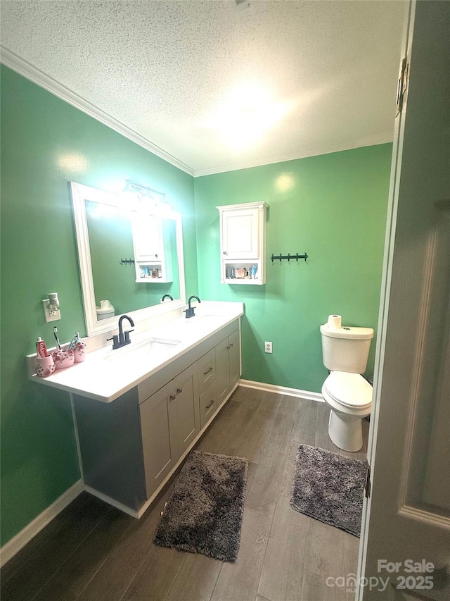 2601 Marldale St, Gastonia, NC 28052 - bathroom with a textured ceiling, wood finished floors, double vanity, toilet, and ornamental molding