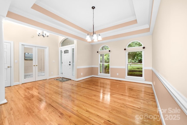 122 Waterford Dr, Mooresville, NC 28117 - unfurnished room with a chandelier, light wood-style floors, a tray ceiling, crown molding, and baseboards