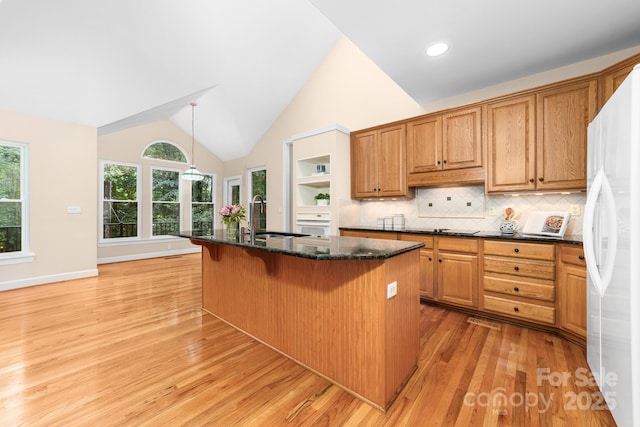 122 Waterford Dr, Mooresville, NC 28117 - kitchen featuring a sink, light wood-style flooring, a breakfast bar, dark stone counters, and white appliances