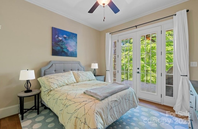 bedroom featuring french doors, access to exterior, wood finished floors, crown molding, and baseboards