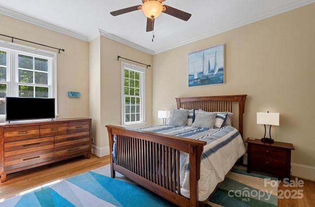 bedroom with wood finished floors, ornamental molding, baseboards, and a ceiling fan