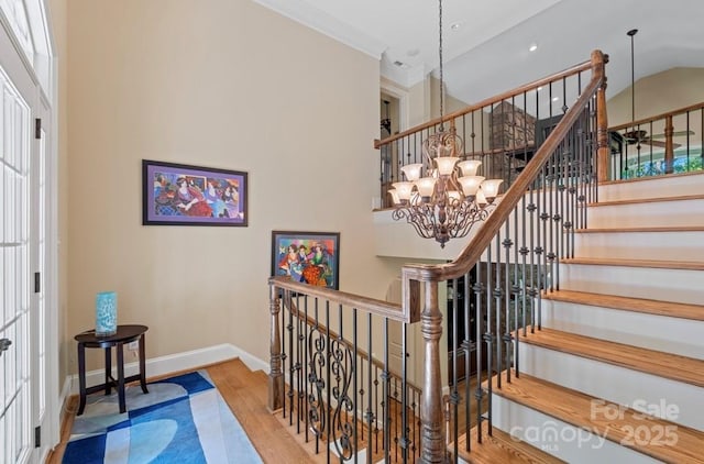 staircase featuring wood finished floors, a chandelier, baseboards, a towering ceiling, and recessed lighting
