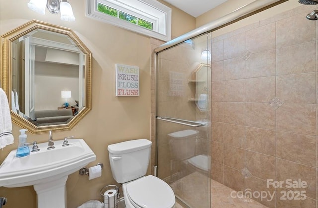 full bathroom with tiled shower and toilet