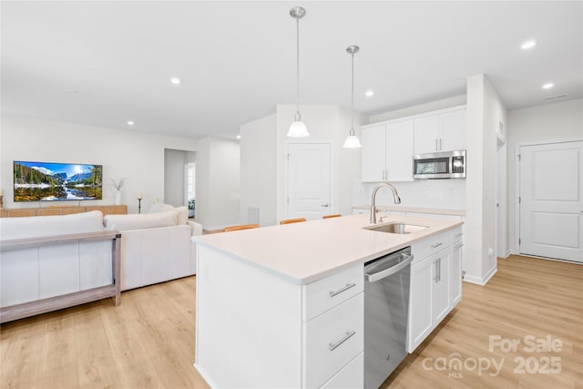 3110 Streamside Dr, Davidson, NC 28036 - kitchen with stainless steel appliances, a sink, light wood finished floors, white cabinetry, and recessed lighting