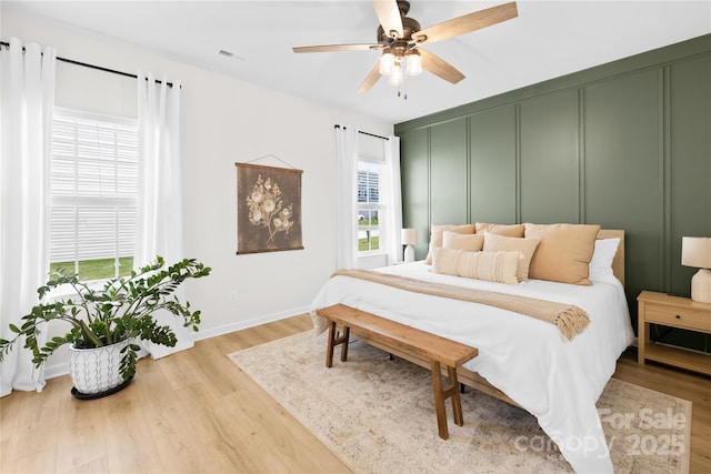 3110 Streamside Dr, Davidson, NC 28036 - bedroom with multiple windows, wood finished floors, baseboards, and a ceiling fan