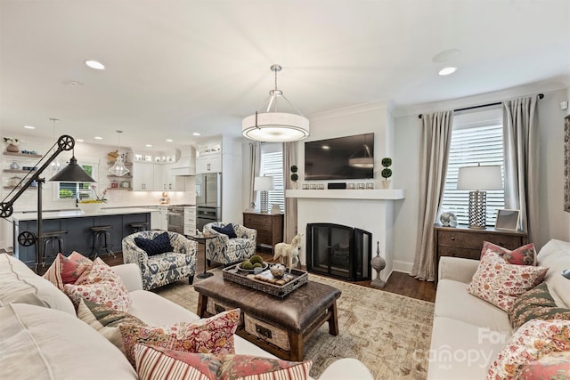 2829 Holt St, Charlotte, NC 28205 - living room with wood finished floors, a glass covered fireplace, recessed lighting, crown molding, and baseboards