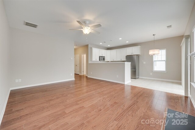 2169 Shady Pond Dr, Clover, SC 29710 - unfurnished living room featuring ceiling fan, light wood-type flooring, baseboards, a chandelier, and recessed lighting