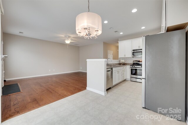 2169 Shady Pond Dr, Clover, SC 29710 - kitchen featuring appliances with stainless steel finishes, a ceiling fan, a chandelier, white cabinetry, and light floors