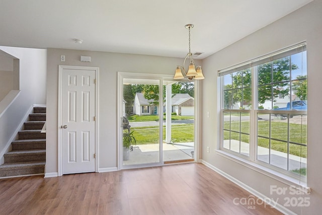 6332 Sackett Way, Charlotte, NC 28269 - unfurnished dining area featuring wood finished floors, baseboards, and stairs