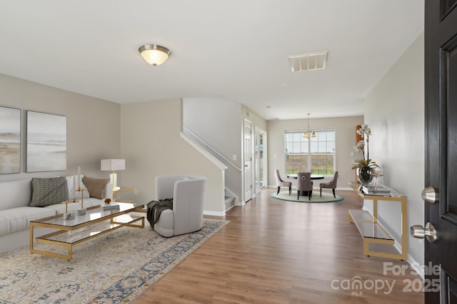 6332 Sackett Way, Charlotte, NC 28269 - living area featuring wood finished floors, baseboards, stairway, and a chandelier