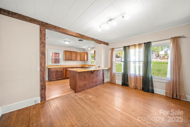 35 Amethyst St, Spruce Pine, NC 28777 - kitchen with brown cabinets, light wood-style flooring, baseboards, and beamed ceiling