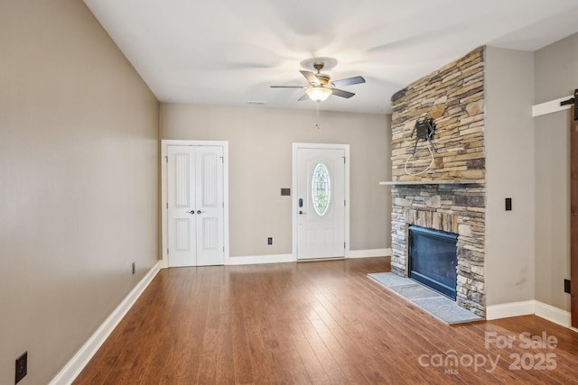 2021 Chantilly Ln, Salisbury, NC 28146 - unfurnished living room featuring ceiling fan, a fireplace, a barn door, and hardwood / wood-style flooring