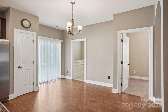2021 Chantilly Ln, Salisbury, NC 28146 - unfurnished dining area with wood finished floors, a chandelier, baseboards, and arched walkways