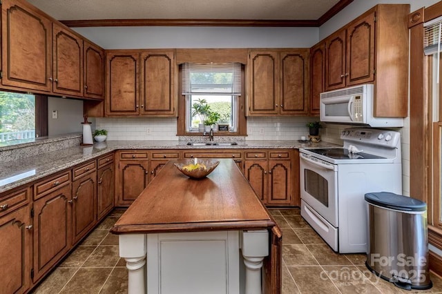 328 E Center Ave, Mooresville, NC 28115 - kitchen featuring white appliances, a sink, brown cabinetry, crown molding, and backsplash