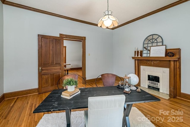 328 E Center Ave, Mooresville, NC 28115 - dining area with crown molding, baseboards, wood finished floors, and a tiled fireplace